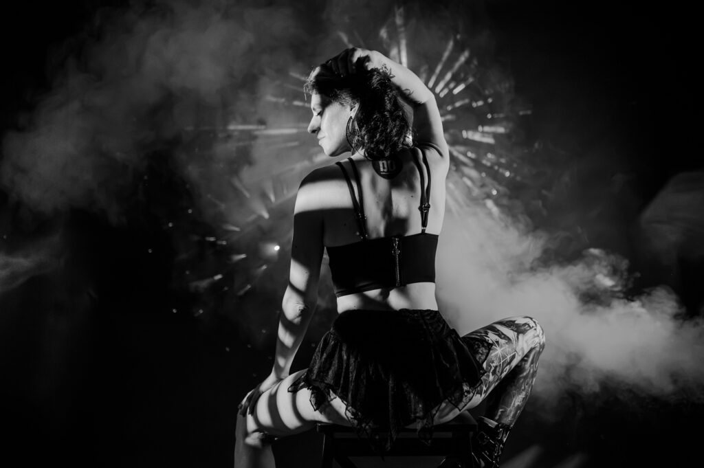 Das Bild zeigt eine beeindruckende Boudoir-Fotografie in Schwarz-Weiß, die eine stilvolle Pose mit Licht- und Schattenspielen kombiniert. Die Aufnahme vermittelt eine geheimnisvolle Atmosphäre und besticht durch ihre künstlerische Ausstrahlung, ideal für Kunstliebhaber in Ingolstadt und Pfaffenhofen.